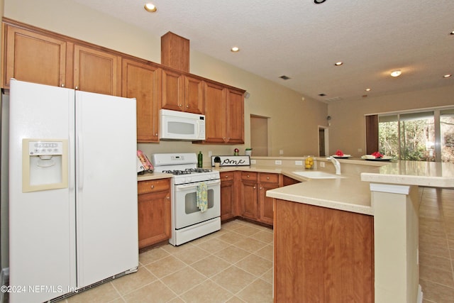 kitchen with sink, a textured ceiling, white appliances, and kitchen peninsula