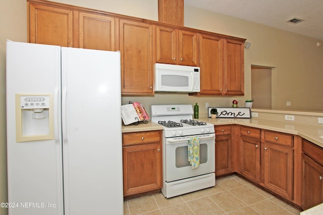 kitchen with white appliances, kitchen peninsula, a textured ceiling, and light tile patterned flooring