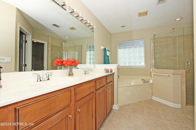 bathroom with shower with separate bathtub, tile patterned floors, a textured ceiling, and vanity