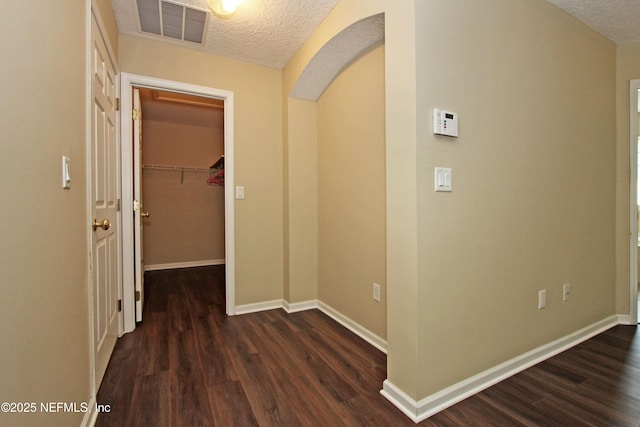 hallway with dark hardwood / wood-style floors and a textured ceiling