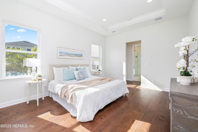 bedroom with wood-type flooring and a raised ceiling