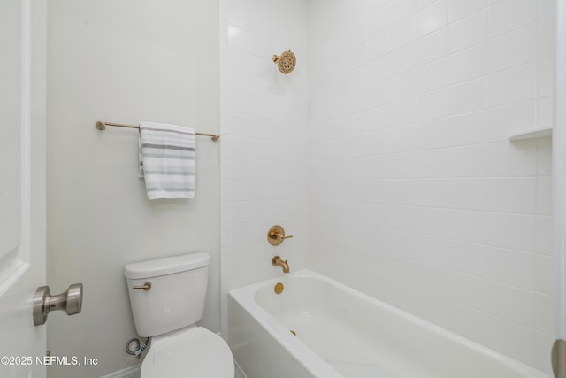 bathroom with tiled shower / bath combo and toilet