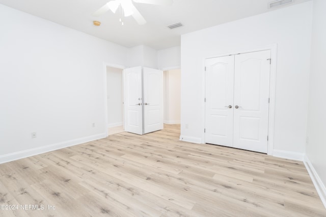 unfurnished bedroom with ceiling fan, light hardwood / wood-style floors, and a closet