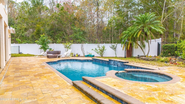 view of swimming pool with an in ground hot tub and a patio