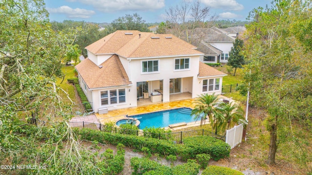 back of property featuring a fenced in pool and a patio