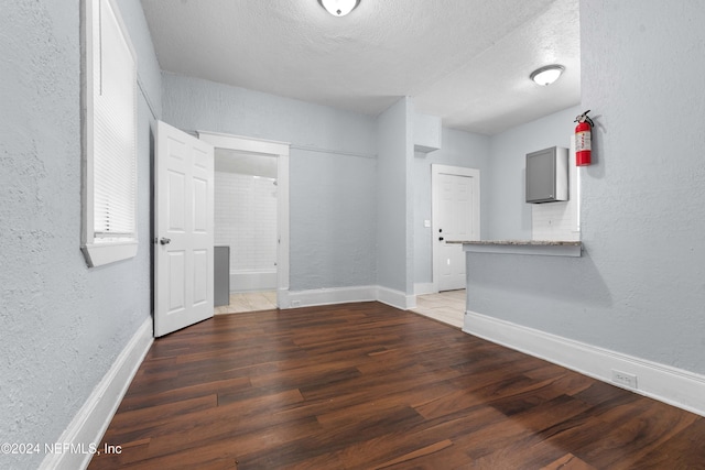 unfurnished room featuring a textured ceiling and dark hardwood / wood-style floors