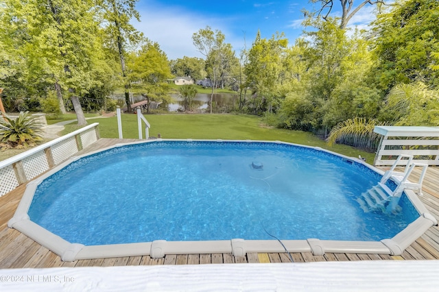 view of pool featuring a lawn and a water view