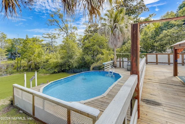 view of swimming pool with a yard and a wooden deck