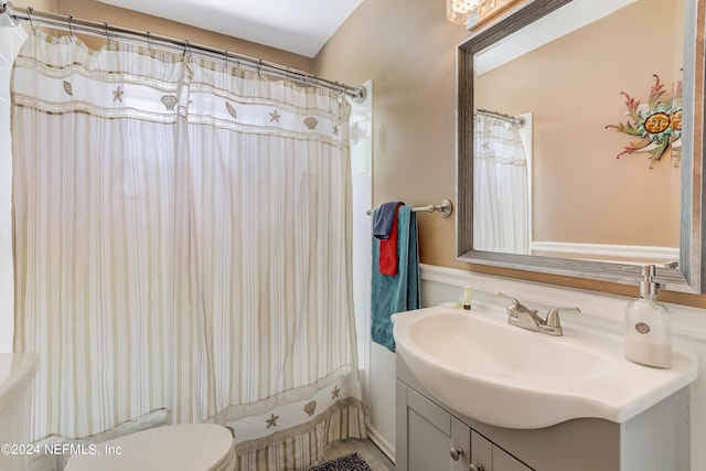 bathroom featuring a shower with shower curtain, vanity, and toilet