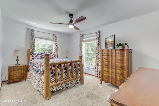 bedroom featuring multiple windows, light carpet, and ceiling fan