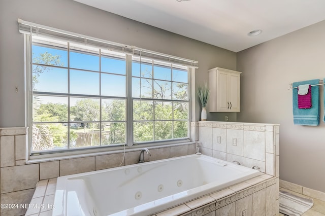 bathroom featuring tile patterned floors, plenty of natural light, and a relaxing tiled tub