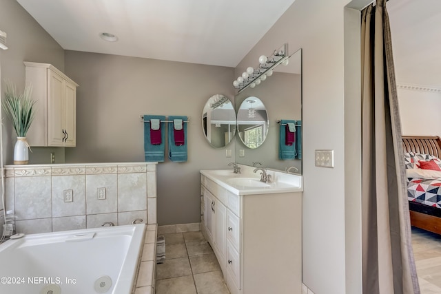 bathroom with tile patterned floors, vanity, and tiled bath