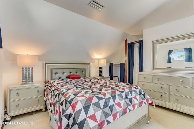 bedroom with light colored carpet and lofted ceiling