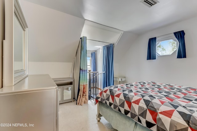 bedroom featuring vaulted ceiling and multiple windows