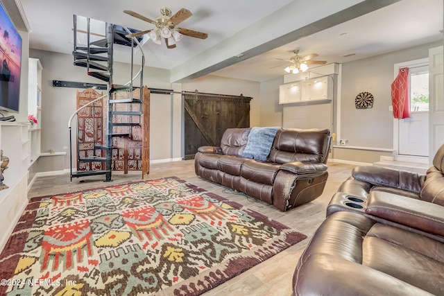 living room featuring a barn door and ceiling fan