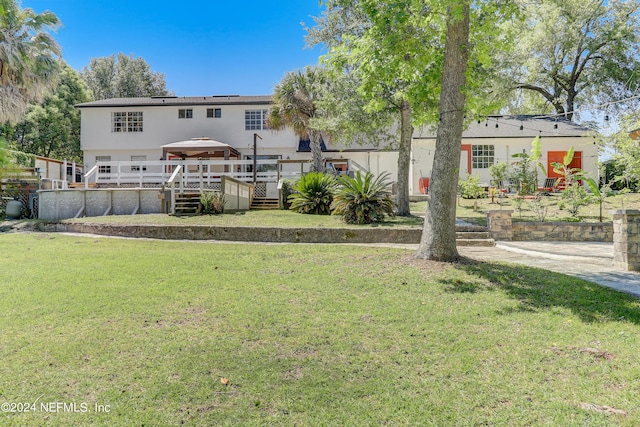 rear view of house with a gazebo, a yard, and a deck