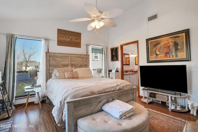 bedroom featuring dark hardwood / wood-style flooring, ensuite bathroom, ceiling fan, and lofted ceiling