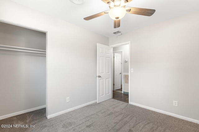 unfurnished bedroom with dark colored carpet, a closet, and ceiling fan