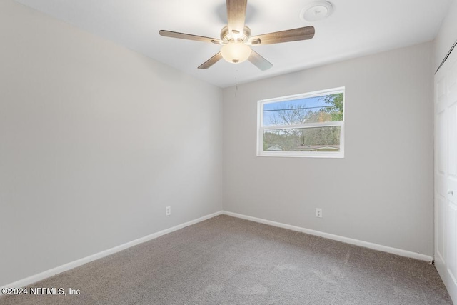 carpeted empty room featuring ceiling fan