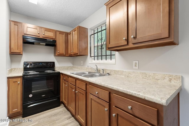 kitchen with a textured ceiling, light hardwood / wood-style flooring, black / electric stove, and sink