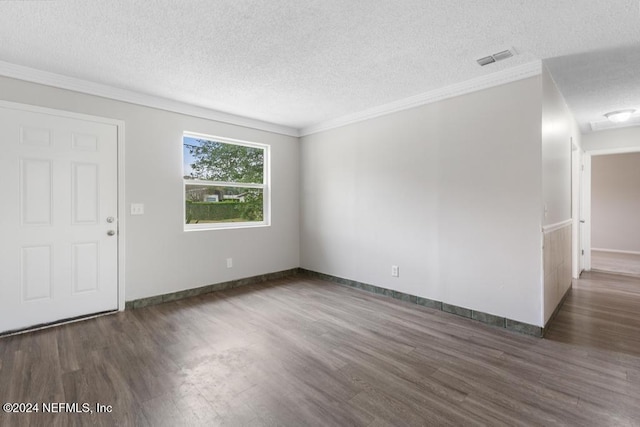 spare room featuring a textured ceiling, crown molding, and dark hardwood / wood-style floors