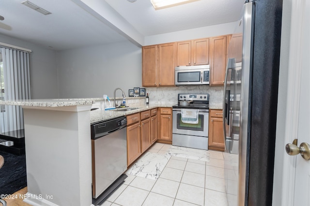 kitchen featuring kitchen peninsula, stainless steel appliances, a breakfast bar area, and sink