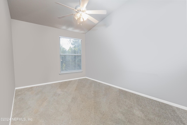 empty room featuring ceiling fan, lofted ceiling, and light carpet