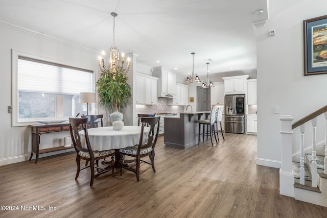 dining room featuring crown molding, hardwood / wood-style floors, and a chandelier