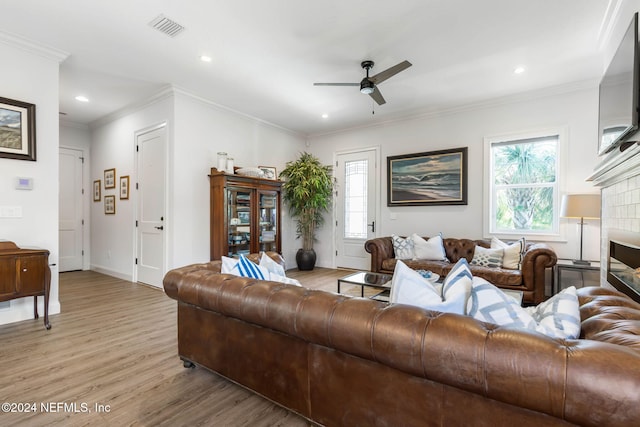 living room with ceiling fan, a healthy amount of sunlight, light wood-type flooring, and crown molding