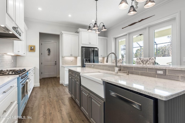 kitchen featuring a center island with sink, white cabinetry, appliances with stainless steel finishes, and tasteful backsplash