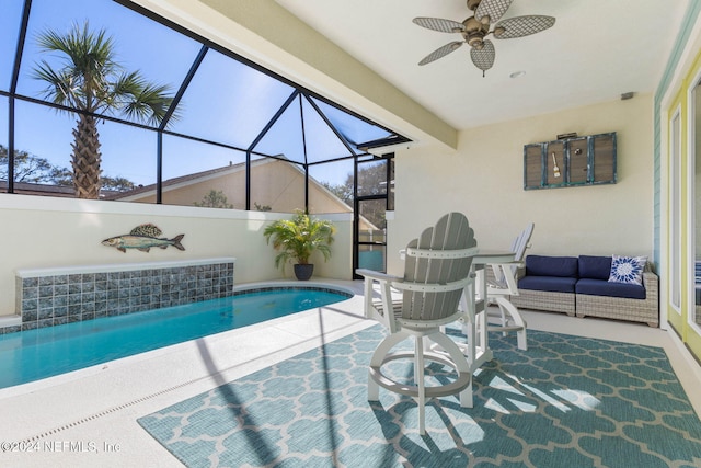 view of swimming pool featuring ceiling fan, a patio area, and a lanai