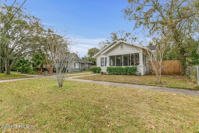 view of front of home with a sunroom and a front lawn