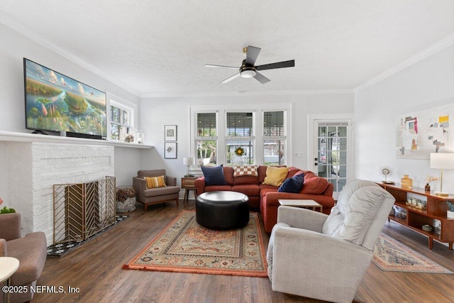 living room featuring ceiling fan, dark hardwood / wood-style flooring, ornamental molding, and a brick fireplace