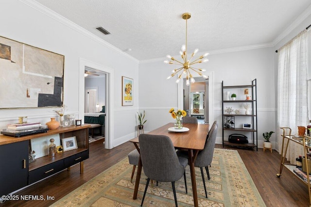 dining room featuring dark hardwood / wood-style floors, crown molding, and an inviting chandelier