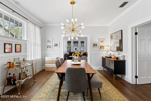 dining room featuring crown molding, dark wood-type flooring, and a notable chandelier