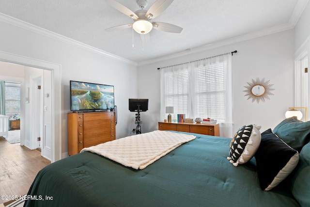 bedroom featuring multiple windows, hardwood / wood-style floors, ceiling fan, and crown molding