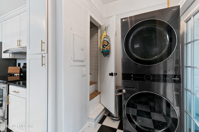 washroom with electric panel and stacked washer and clothes dryer