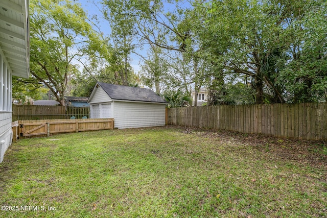 view of yard with a garage and an outbuilding