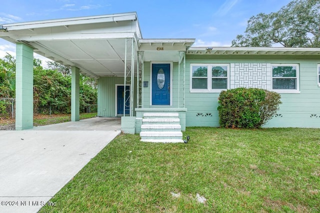 view of front of house with a front lawn and a carport