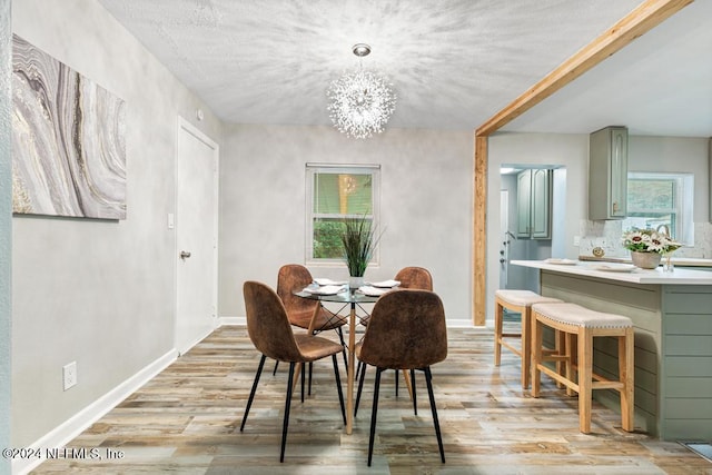 dining area with light wood-type flooring and an inviting chandelier