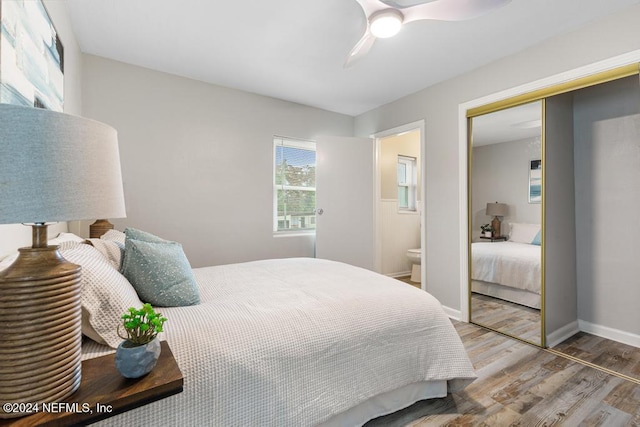 bedroom with hardwood / wood-style floors, ceiling fan, ensuite bathroom, and a closet