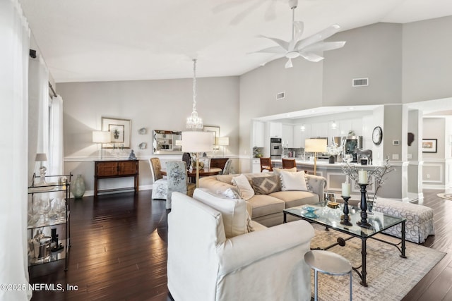 living room featuring ceiling fan, high vaulted ceiling, and dark wood-type flooring