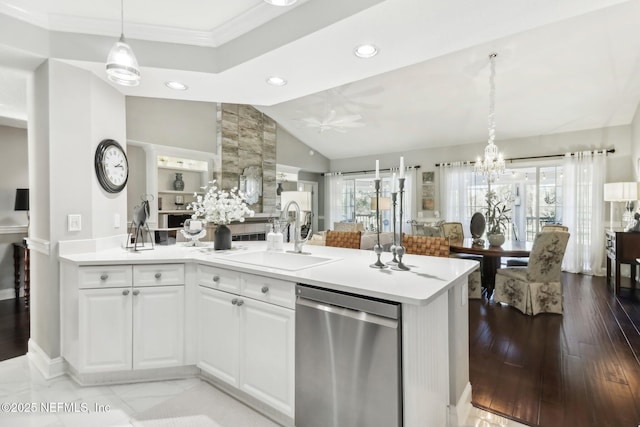 kitchen with dishwasher, sink, pendant lighting, vaulted ceiling, and white cabinets