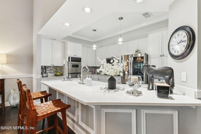 kitchen featuring white cabinets, a kitchen breakfast bar, sink, a large island, and stainless steel appliances