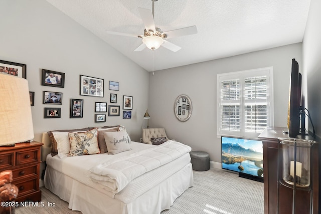 bedroom with ceiling fan, lofted ceiling, and a textured ceiling