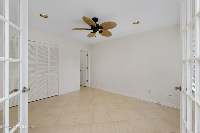 unfurnished bedroom featuring french doors, a closet, light tile patterned floors, and ceiling fan