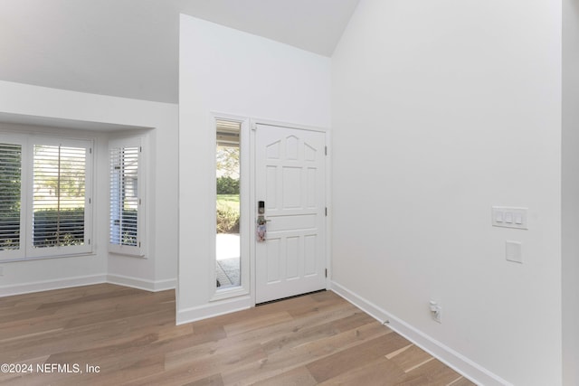 entryway featuring light wood-type flooring and vaulted ceiling