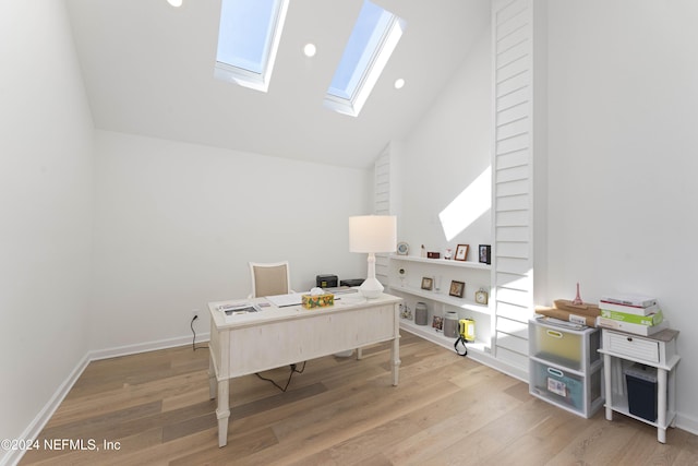 office area featuring wood-type flooring, a skylight, and high vaulted ceiling