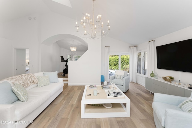 living room featuring light wood-type flooring, high vaulted ceiling, and a chandelier