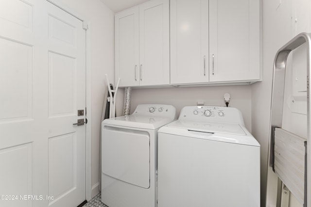 clothes washing area featuring cabinets and independent washer and dryer